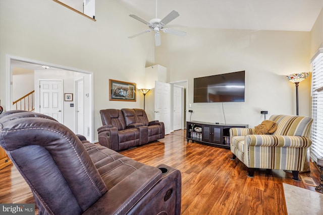 living room featuring a high ceiling, wood finished floors, and a ceiling fan