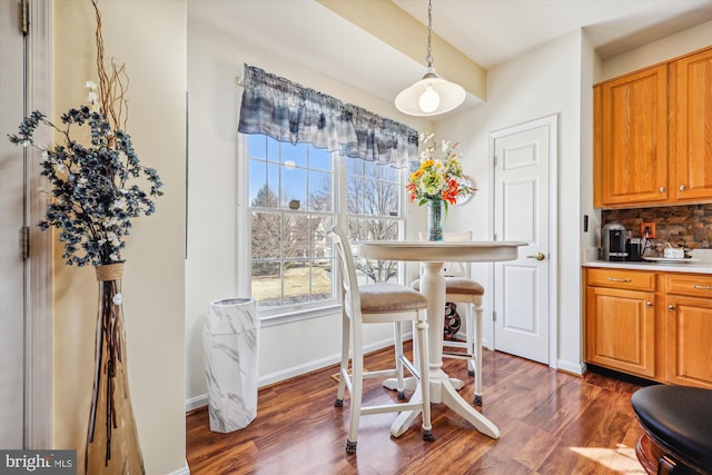 dining space featuring dark wood-style flooring and baseboards