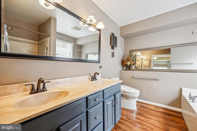 full bathroom featuring visible vents, wood finished floors, a sink, and a bath