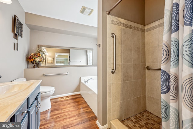 bathroom featuring a garden tub, visible vents, a tile shower, vanity, and wood finished floors