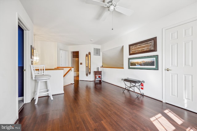 interior space featuring a ceiling fan, baseboards, visible vents, and wood finished floors