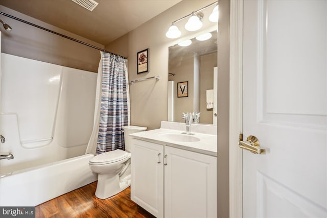 bathroom featuring shower / tub combo with curtain, visible vents, toilet, vanity, and wood finished floors