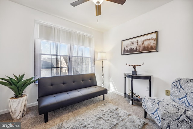 living area featuring ceiling fan, carpet flooring, and baseboards