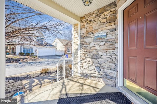 view of exterior entry with stone siding and a porch