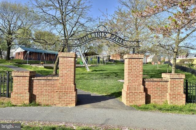 view of gate with a yard and fence