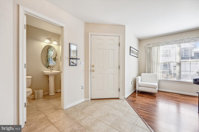 foyer with light tile patterned flooring and baseboards