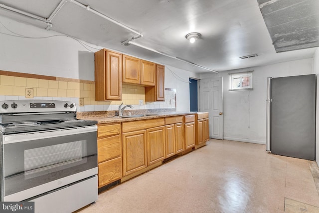 kitchen featuring light floors, light countertops, visible vents, appliances with stainless steel finishes, and a sink