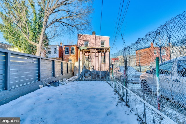 snowy yard featuring fence