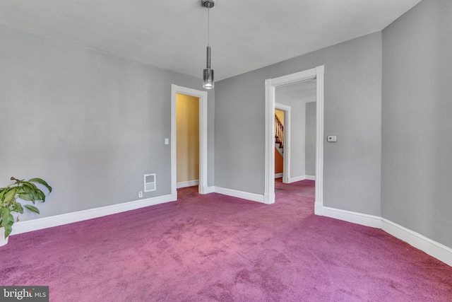 carpeted empty room featuring visible vents and baseboards