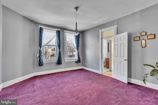 carpeted spare room featuring baseboards