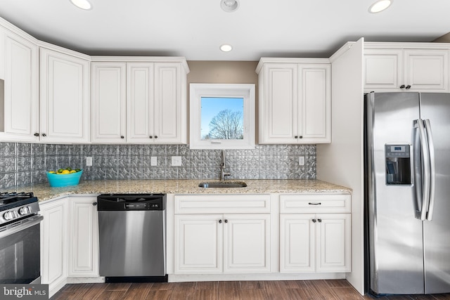 kitchen with dark wood-style floors, stainless steel appliances, a sink, and white cabinetry