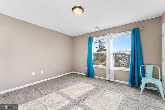 unfurnished room with carpet flooring, visible vents, and baseboards