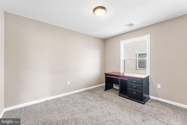 unfurnished office with carpet, visible vents, and baseboards