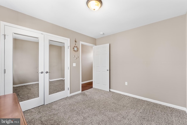 unfurnished bedroom featuring carpet floors, french doors, a closet, and baseboards