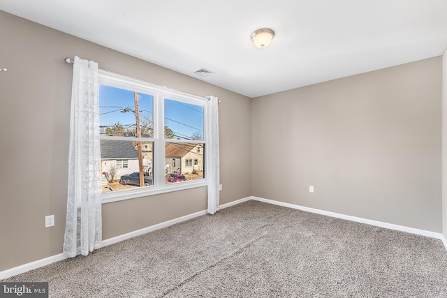 unfurnished room with carpet flooring, visible vents, and baseboards