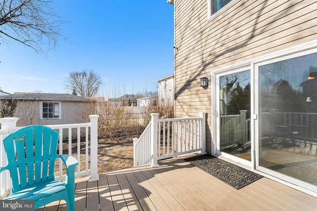 wooden terrace featuring an outdoor structure and fence