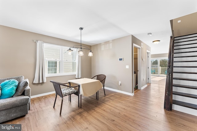 dining room with stairs, light wood-type flooring, and baseboards