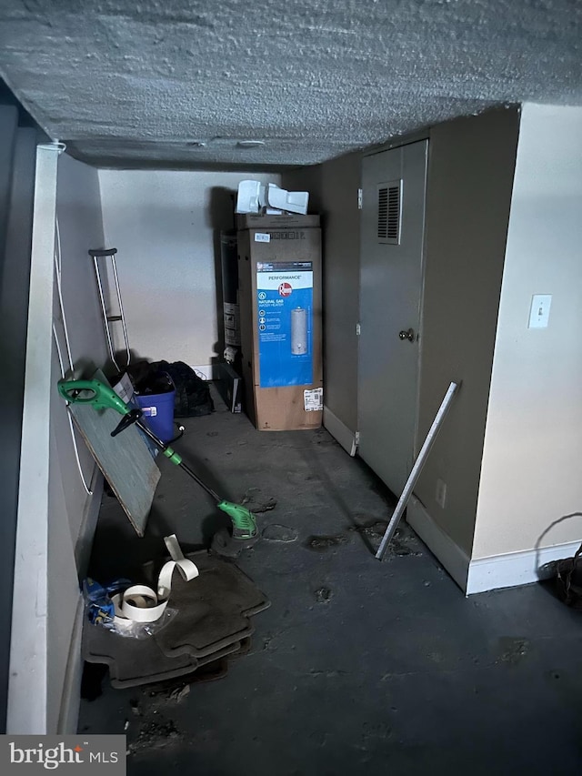 interior space with visible vents, a textured ceiling, and baseboards