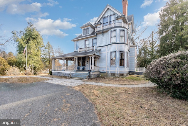 victorian home with a porch and a chimney