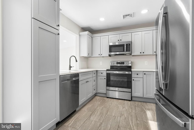 kitchen featuring recessed lighting, a sink, visible vents, light countertops, and appliances with stainless steel finishes