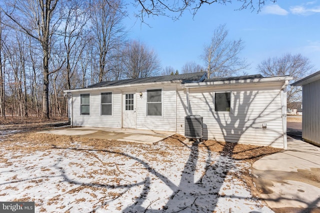 snow covered house featuring a patio area and central air condition unit