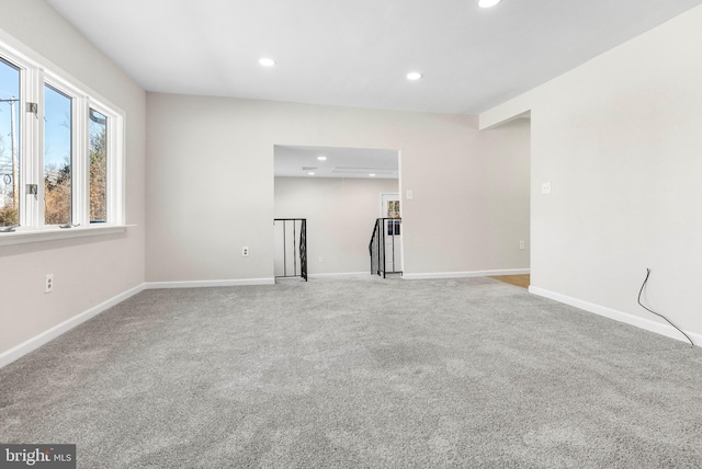 carpeted spare room featuring baseboards and recessed lighting