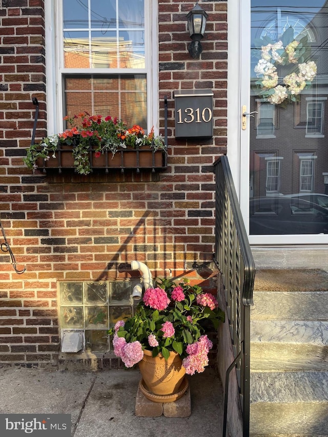 entrance to property featuring brick siding