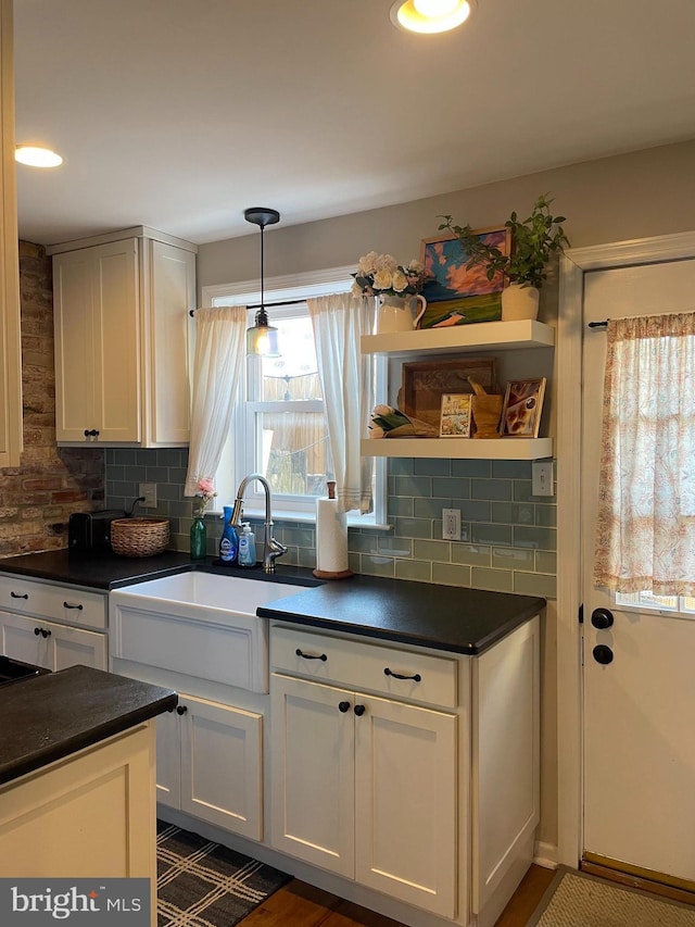 kitchen featuring dark countertops, white cabinetry, open shelves, and decorative light fixtures