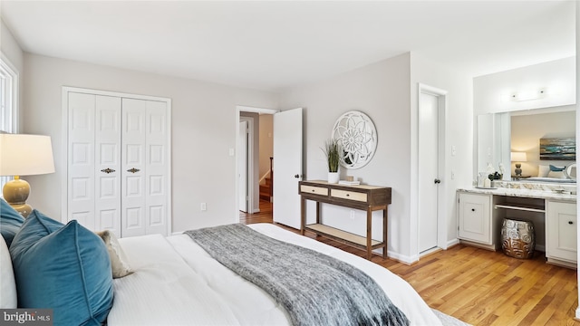 bedroom with light wood finished floors and a closet