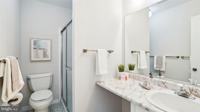 bathroom with a shower stall, toilet, and vanity