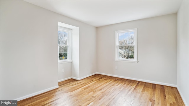 unfurnished room with light wood finished floors and baseboards