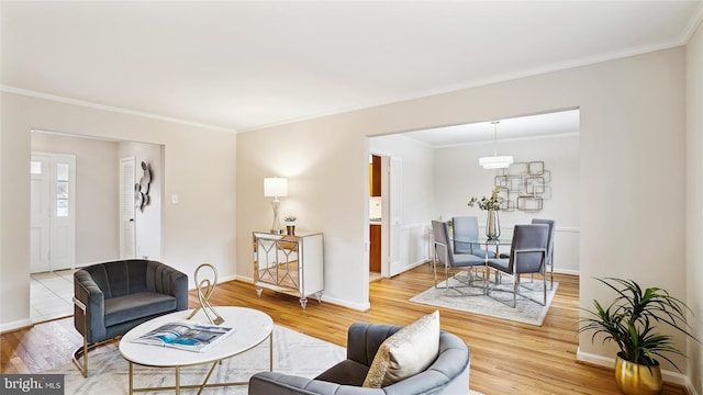 living room featuring crown molding, wood finished floors, and baseboards