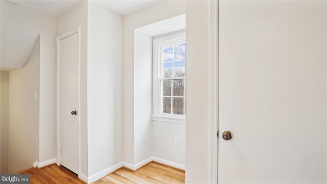 hall with light wood finished floors and baseboards