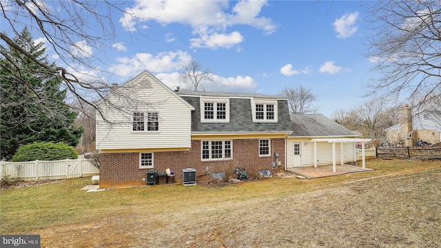 back of property featuring cooling unit, a fenced backyard, brick siding, a yard, and a patio area