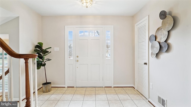 entrance foyer featuring light tile patterned floors, baseboards, stairs, and visible vents