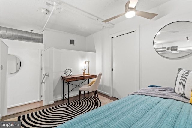 bedroom featuring wood finished floors, visible vents, and baseboards