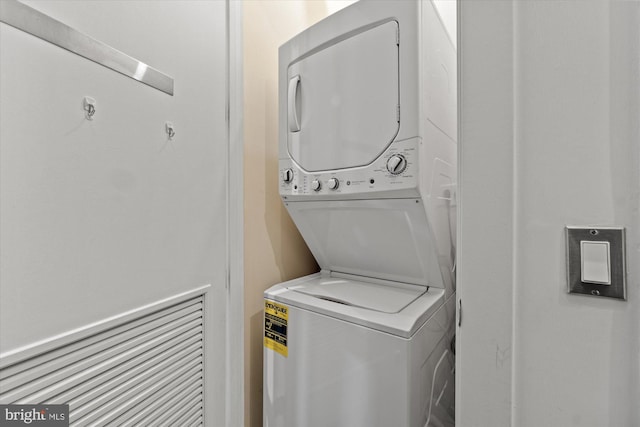 washroom with stacked washer and dryer and laundry area