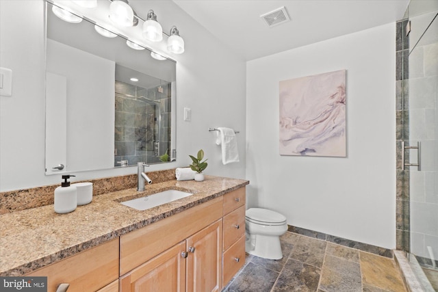 bathroom featuring toilet, vanity, visible vents, baseboards, and a shower stall