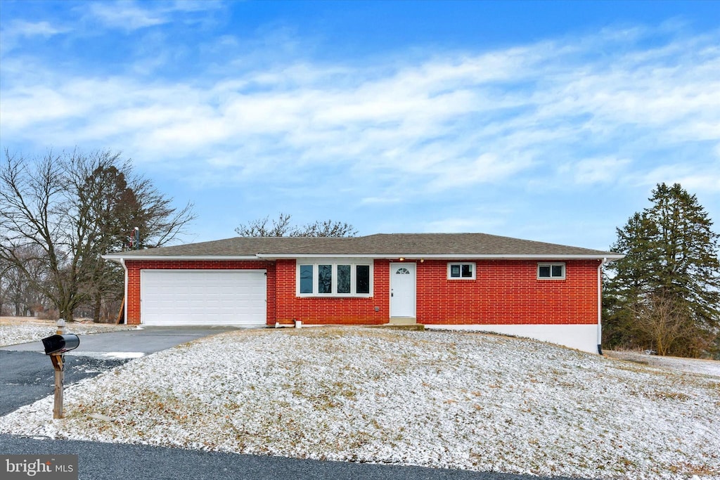 ranch-style house with driveway, brick siding, and an attached garage