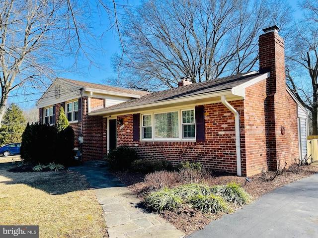 view of front of property with brick siding and a chimney