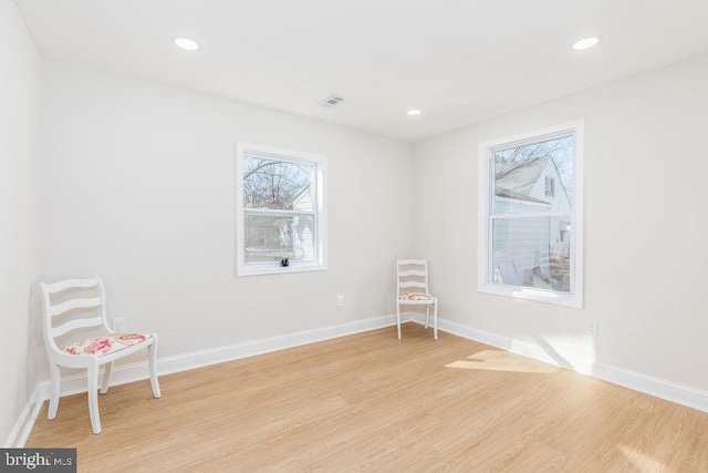 unfurnished room with baseboards, light wood finished floors, and a healthy amount of sunlight