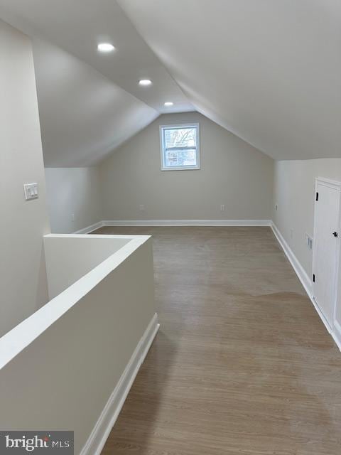 additional living space featuring lofted ceiling, recessed lighting, wood finished floors, and baseboards