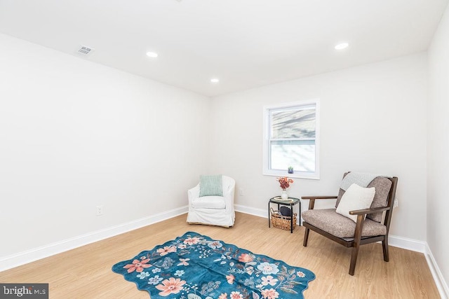 living area with recessed lighting, light wood-type flooring, visible vents, and baseboards