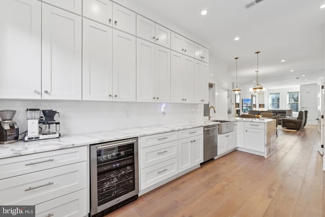 kitchen with wine cooler, open floor plan, decorative light fixtures, white cabinetry, and stainless steel dishwasher