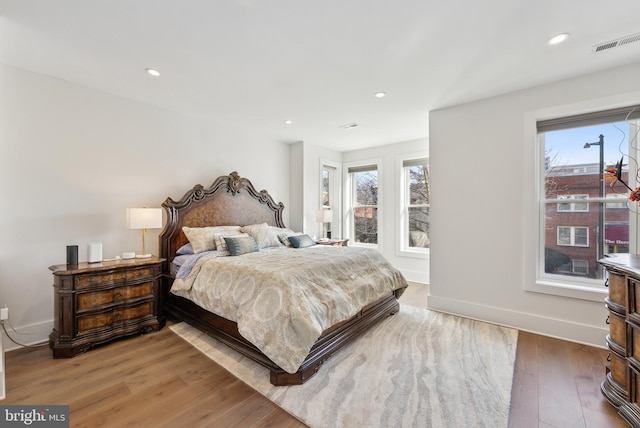 bedroom featuring multiple windows, visible vents, wood finished floors, and recessed lighting