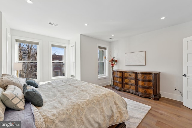 bedroom with light wood-type flooring, visible vents, recessed lighting, and multiple windows