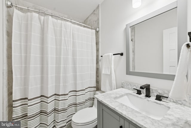 bathroom with toilet, a shower with shower curtain, and vanity