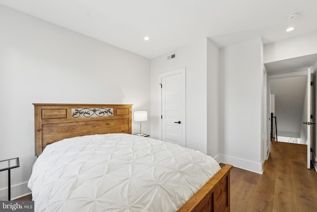 bedroom with baseboards, dark wood finished floors, visible vents, and recessed lighting