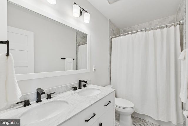 full bathroom featuring curtained shower, a sink, toilet, and double vanity