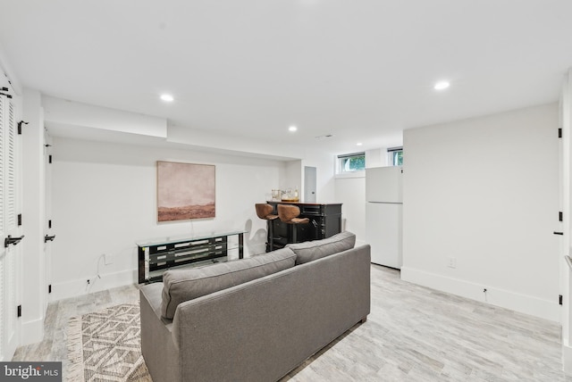 living room with baseboards, light wood finished floors, and recessed lighting